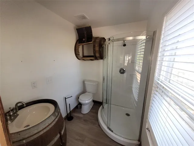 a bathroom with a granite countertop sink toilet and shower