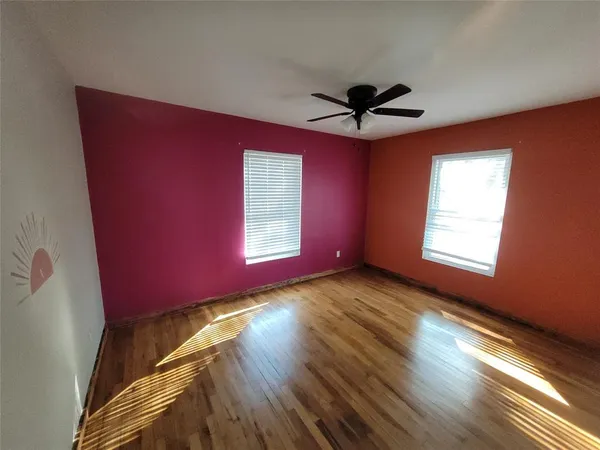 a view of a room with window a ceiling fan and wooden floor