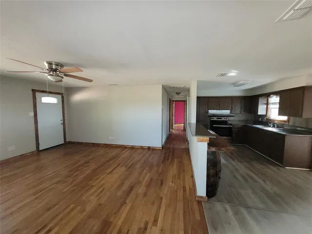 a view of a living room hardwood floor and a kitchen