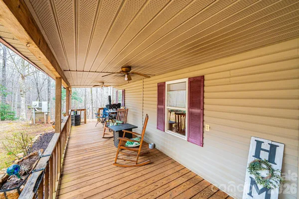 a view of a patio with table and chairs with wooden floor and fence