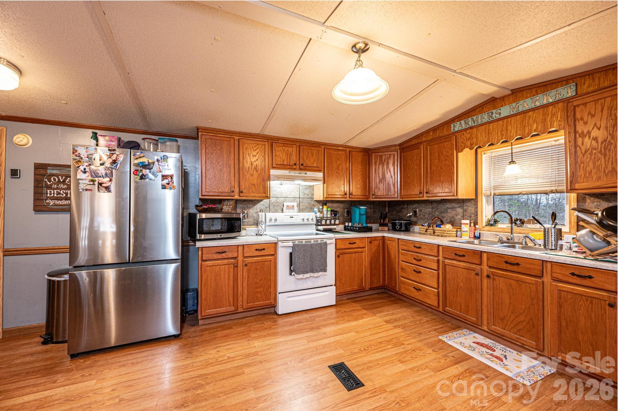 173 Croom Hollow Road Nebo, NC 28761 - Photo 21 of 43 a kitchen with stainless steel appliances granite countertop a refrigerator a sink dishwasher a stove and white cabinets with wooden floor