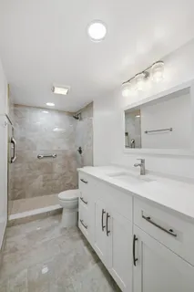 a bathroom with a double vanity sink toilet and shower
