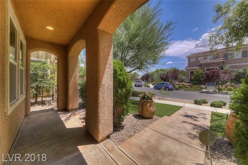 3144 Whitfeild Avenue Henderson, NV 89044 - Photo 3 of 55 Arched entryways welcome guests to this charming residence, framed by mature trees and manicured landscaping.