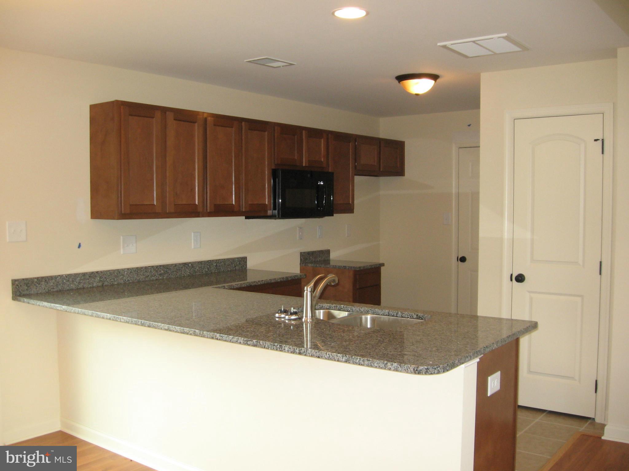 58 Gibson Road Inwood, WV 25428 - Photo 5 of 17 a kitchen with granite countertop a sink a stove and cabinets