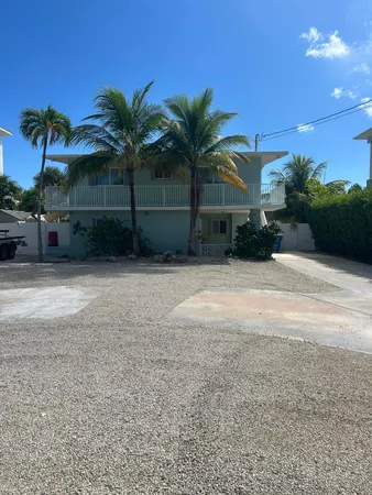 a view of a house with a yard and potted plants