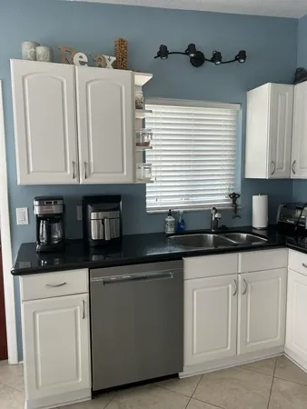 a kitchen with granite countertop white cabinets and sink
