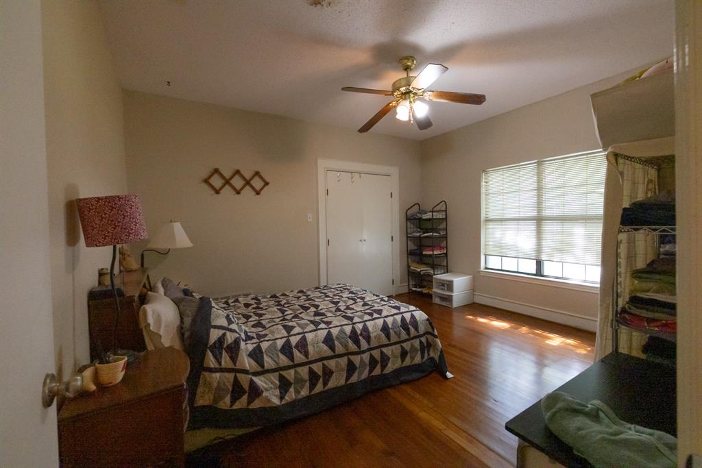 700 North Beacon Street Dallas, TX 75214 - Photo 9 of 13 a bedroom with a bed and dresser with wooden floor