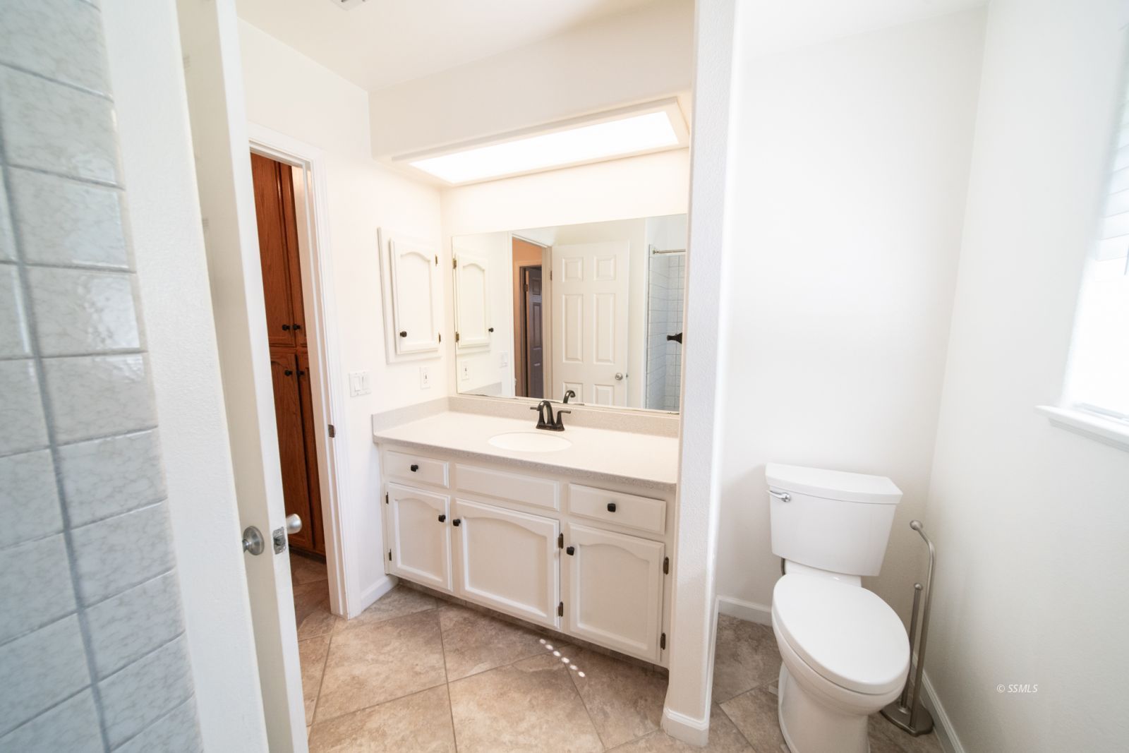 1205 Flora Way Ridgecrest, CA 93555 - Photo 36 of 46 a spacious bathroom with a toilet a sink and a mirror