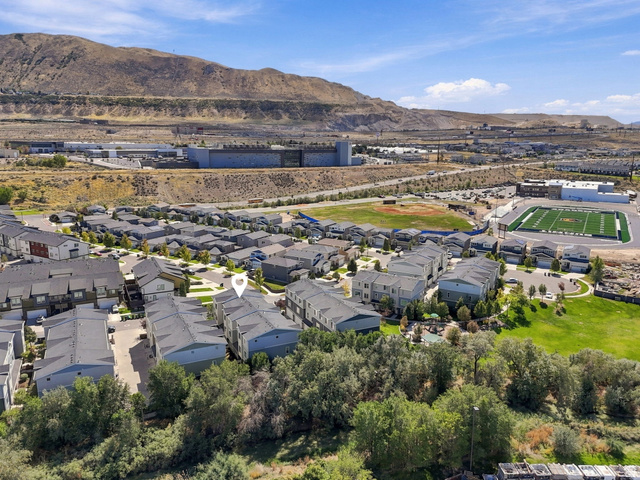 14764 Rising Star Way Riverton, UT 84065 - Photo 39 of 42 Modern townhome community with a mountainous backdrop, adjacent to a sports field and green spaces
