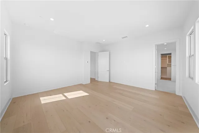 a view of an empty room with a cabinet and mirror