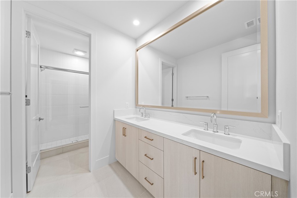 100 Mossvine Irvine, CA 92618 - Photo 28 of 44 a spacious bathroom with a shower sink and mirror