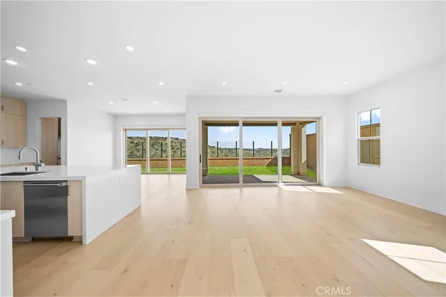 a kitchen that has a lot of white cabinets and wooden floor