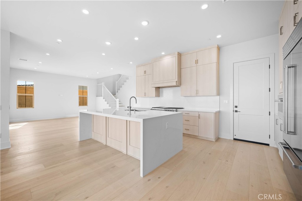 100 Mossvine Irvine, CA 92618 - Photo 9 of 44 a kitchen that has a lot of white cabinets and wooden floor