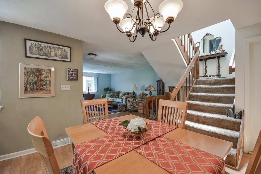 124 Mountain Gate Road, Unit 124 Ashland, MA 01721 - Photo 13 of 19 a view of a dining room with furniture a chandelier and wooden floor