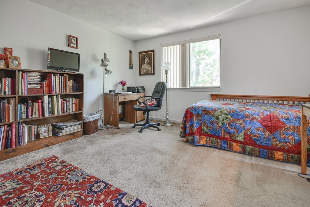 124 Mountain Gate Road, Unit 124 Ashland, MA 01721 - Photo 16 of 19 a bedroom with bed furniture and a book shelf