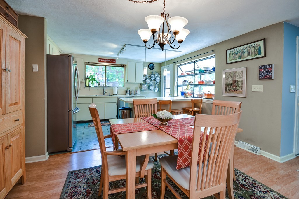 124 Mountain Gate Road, Unit 124 Ashland, MA 01721 - Photo 9 of 19 a view of a dining room with furniture a chandelier and wooden floor