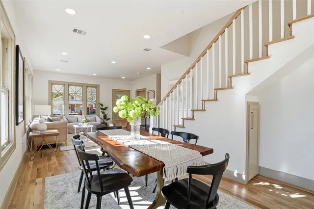 a kitchen with stainless steel appliances kitchen island granite countertop a stove a sink dishwasher and white cabinets with wooden floor