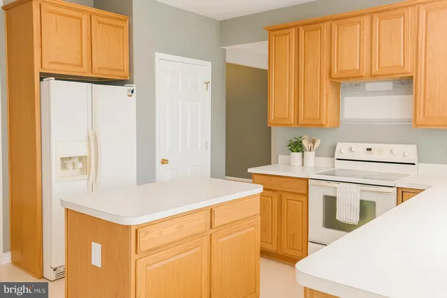 a kitchen with a sink a stove cabinets and a refrigerator