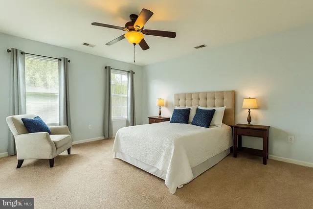 a bedroom with a bed a couch and a chandelier