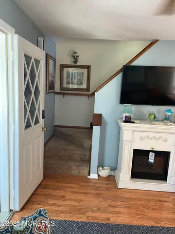 a view of a livingroom with wooden floor and a fireplace