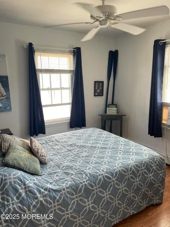 a bedroom with a bed and a flat tv screen on dresser