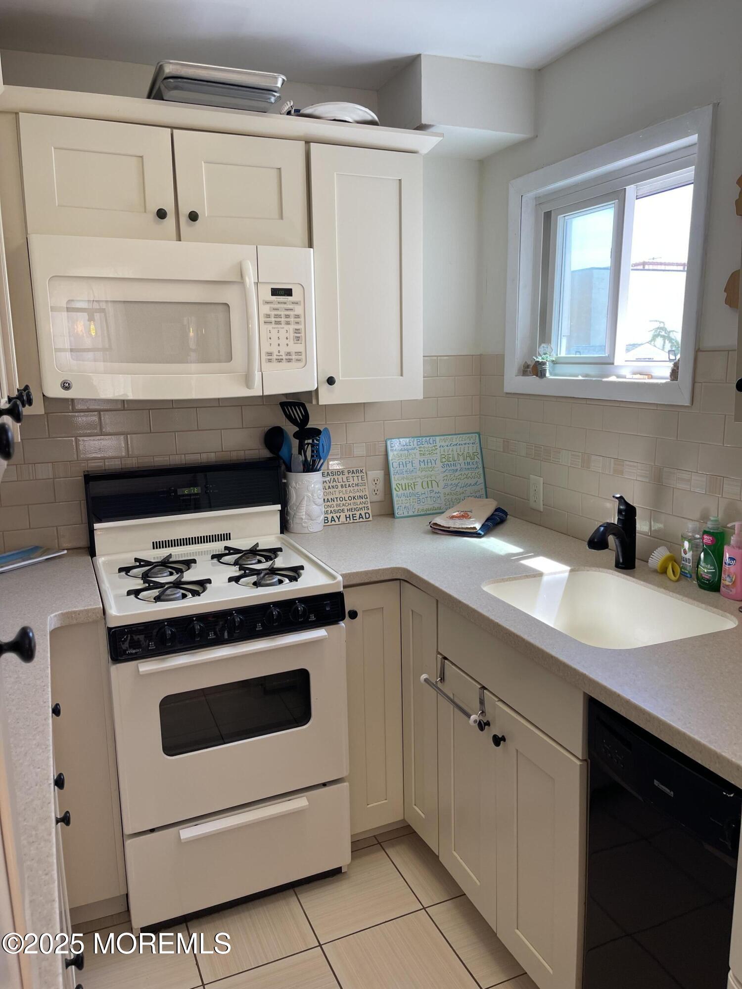 102 Brown Avenue Lavallette, NJ 08735 - Photo 2 of 22 a kitchen with cabinets appliances and a window