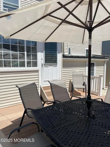 a view of backyard with table and chairs under an umbrella