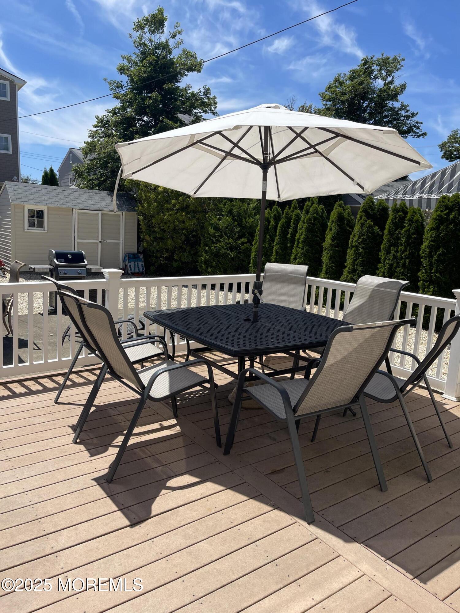 102 Brown Avenue Lavallette, NJ 08735 - Photo 22 of 22 a view of backyard with table and chairs under an umbrella