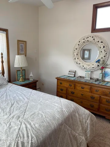 a bedroom with a bed and a mirror on dresser