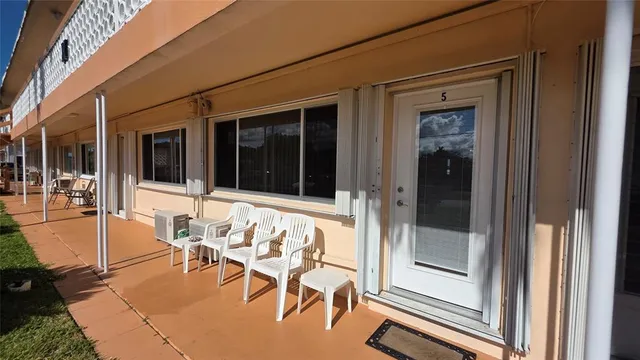 a view of a porch with a dining table and chairs