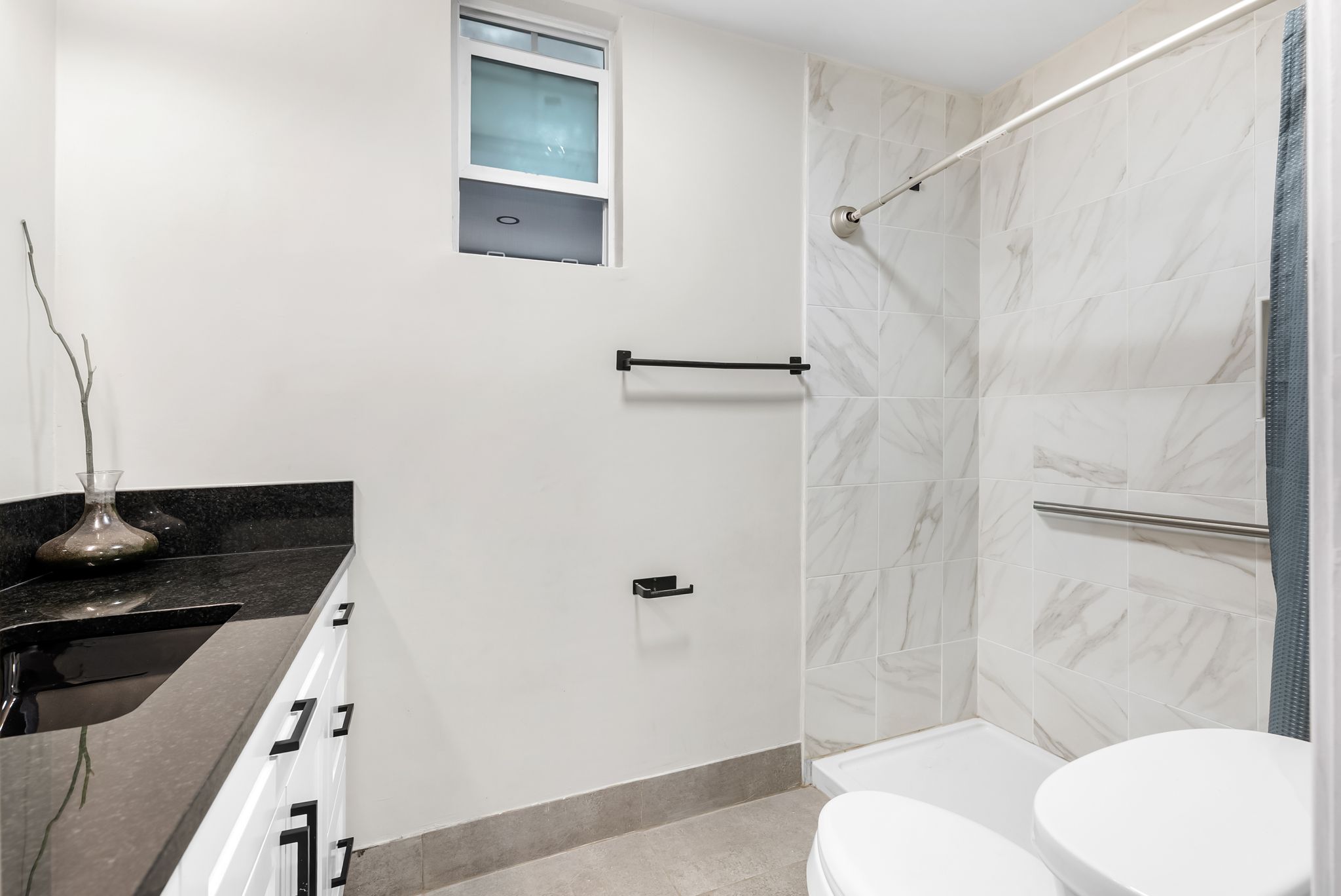 2201 Teri Road Austin, TX 78744 - Photo 13 of 37 a bathroom with a granite countertop sink toilet and shower