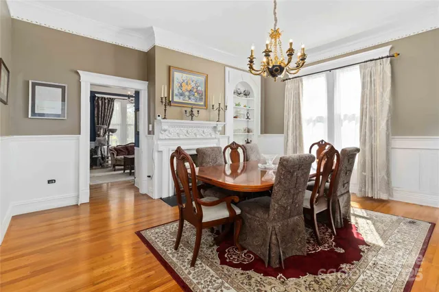 a dining room with furniture a chandelier and wooden floor