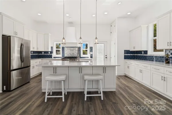 a kitchen with stainless steel appliances granite countertop a table chairs stove microwave and cabinets