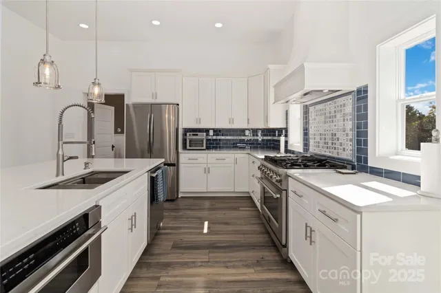 a kitchen with stainless steel appliances granite countertop a sink stove and refrigerator
