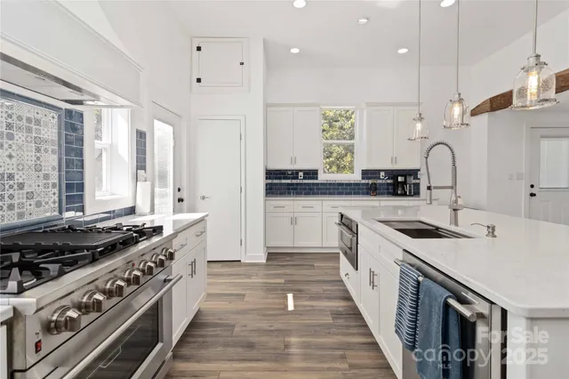 a kitchen with stainless steel appliances a sink stove and cabinets