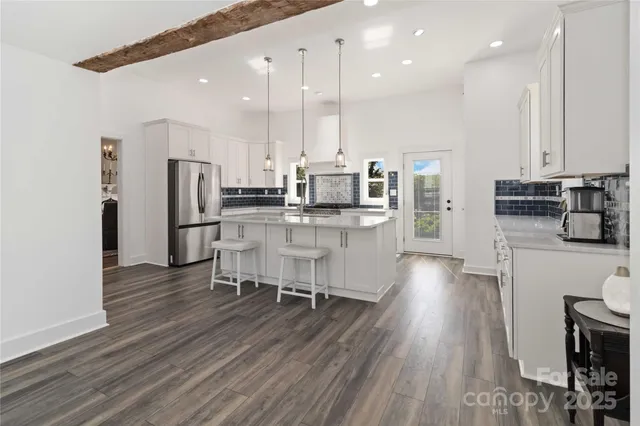 a kitchen with stainless steel appliances kitchen island wooden cabinets and refrigerator