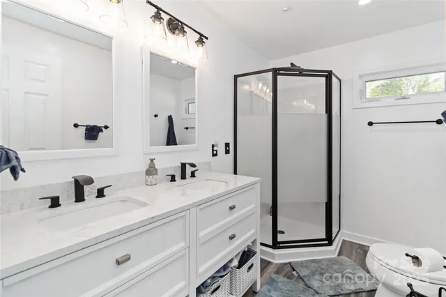 a bathroom with a sink a toilet and shower