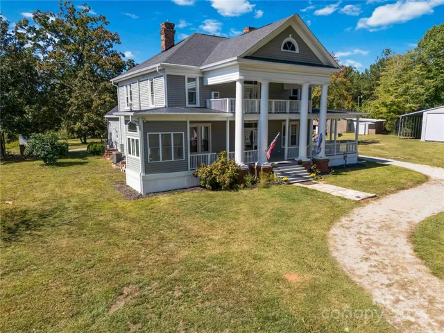 a view of a house with wooden walls and a yard in front of it