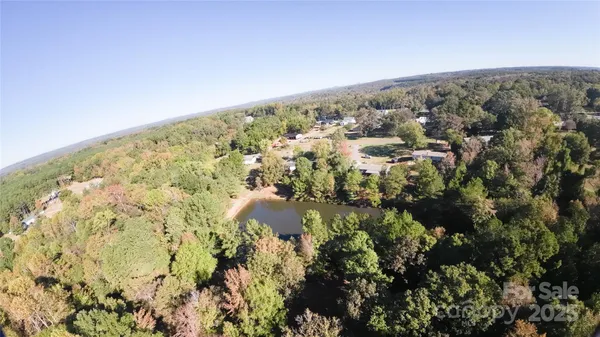 an aerial view of residential house with green space and fog