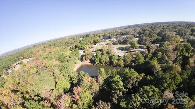 an aerial view of residential house with green space and fog