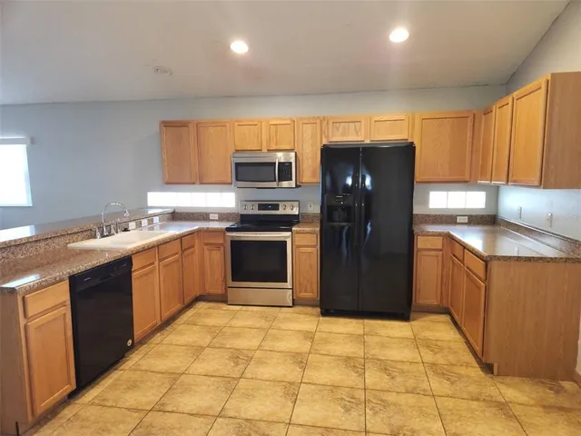 a kitchen with stainless steel appliances granite countertop a refrigerator and a sink