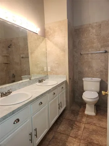 a spacious bathroom with a toilet sink and mirror