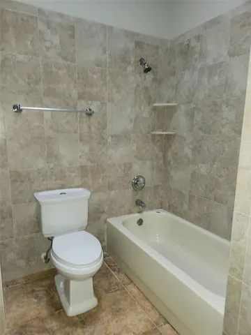 a white toilet sitting next to a bath tub