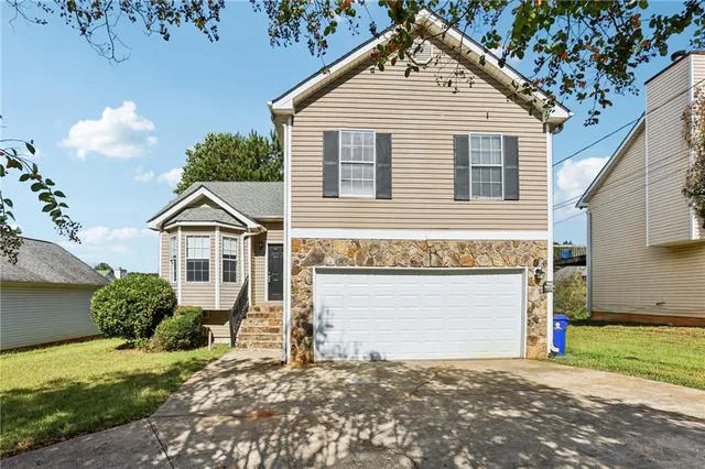 a front view of a house with a yard and garage