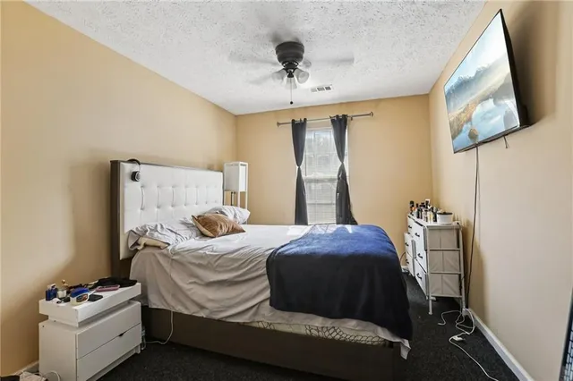 a bedroom with a bed and a flat tv screen on the dresser