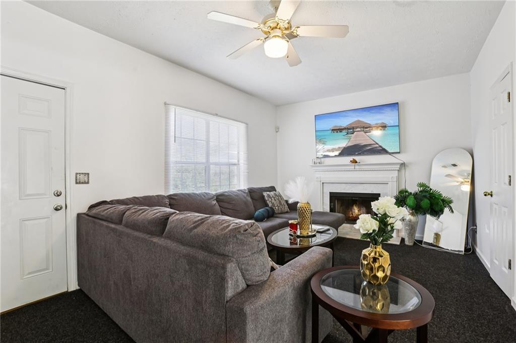 4031 Robin Circle Atlanta, GA 30349 - Photo 16 of 23 a living room with furniture a fireplace and a flat screen tv