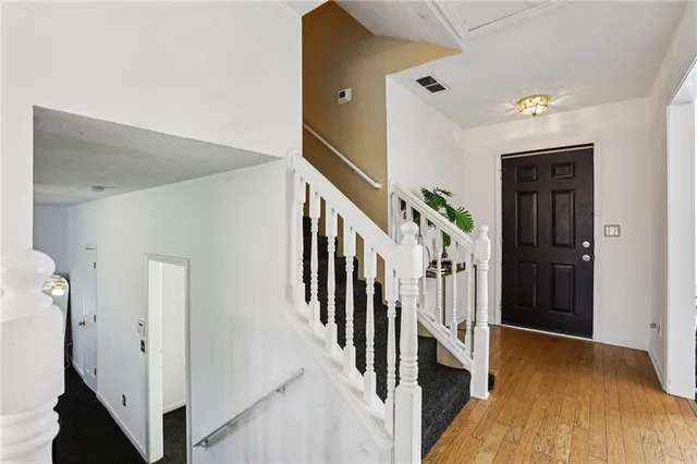 a view of hallway with stairs and wooden floor