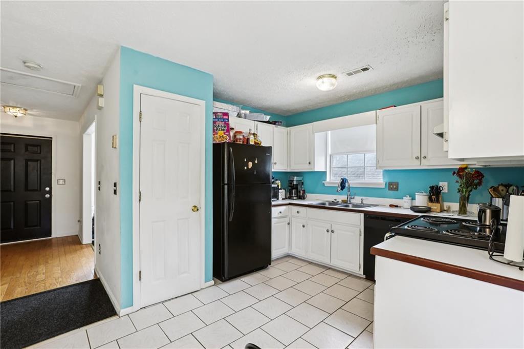 4031 Robin Circle Atlanta, GA 30349 - Photo 4 of 23 a kitchen with a refrigerator sink and cabinets