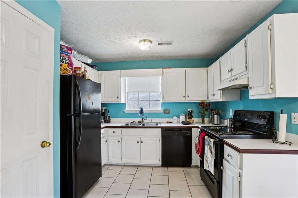 4031 Robin Circle Atlanta, GA 30349 - Photo 5 of 23 a kitchen with a sink a refrigerator and cabinets