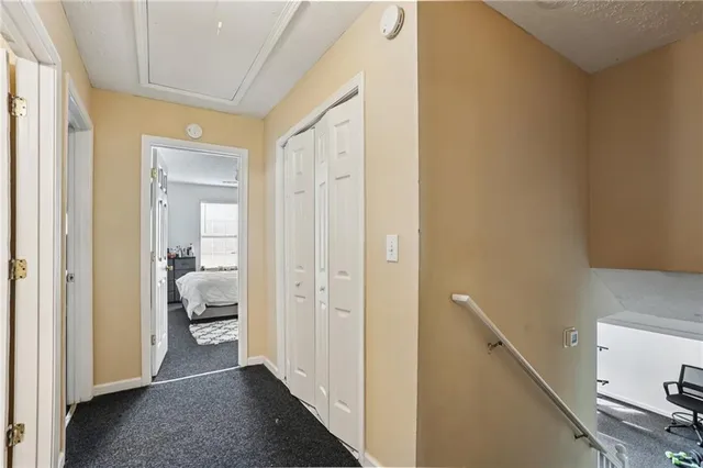 a view of a hallway with a livingroom and a bathroom